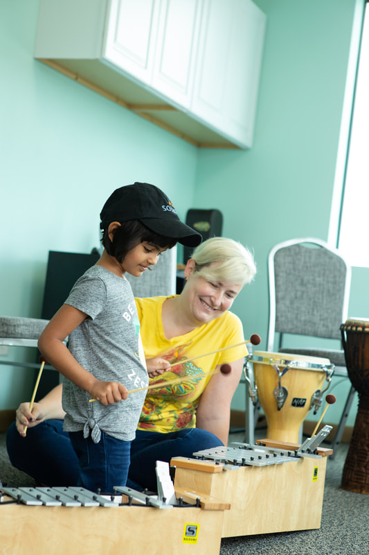Teacher with student playing xylophone