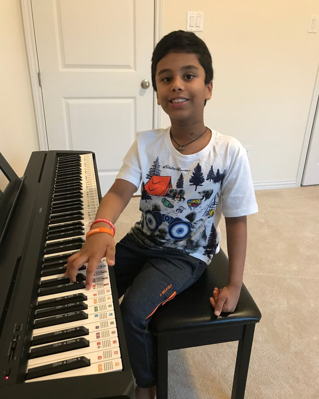 Student showing off bracelets while playing piano