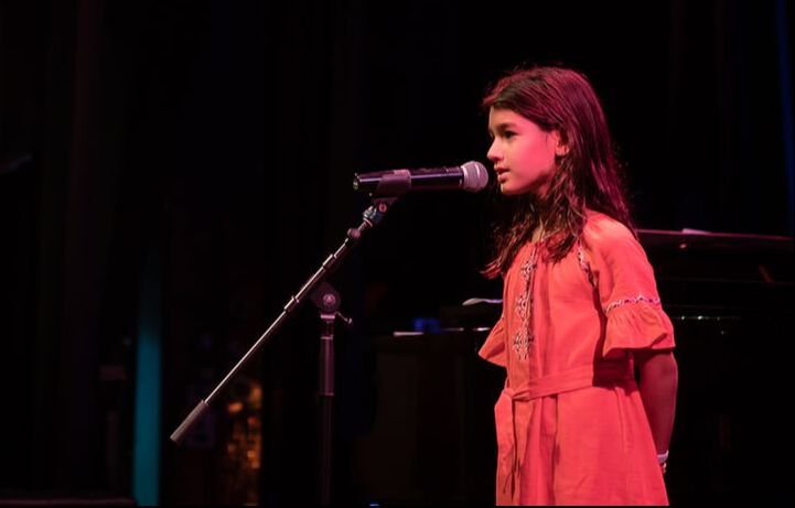 Girl performing with microphone on stage