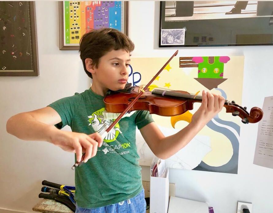 Student holding violin in set up