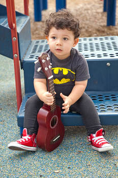 Child holding ukulele on playground