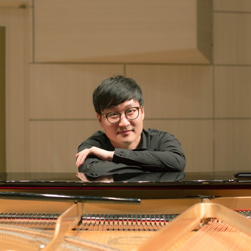 Han-Sae Jang sitting with arms on piano