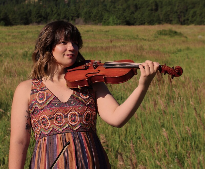 Mackenzie Hoffman holding violin in a field